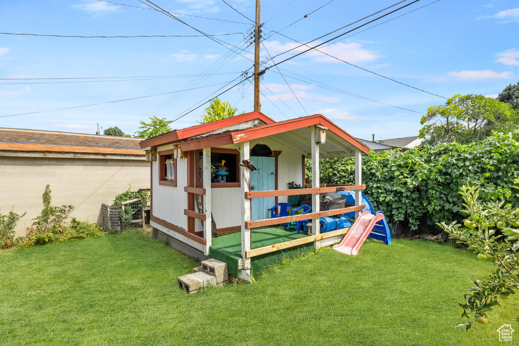 Rear view of property with a yard and an outdoor structure