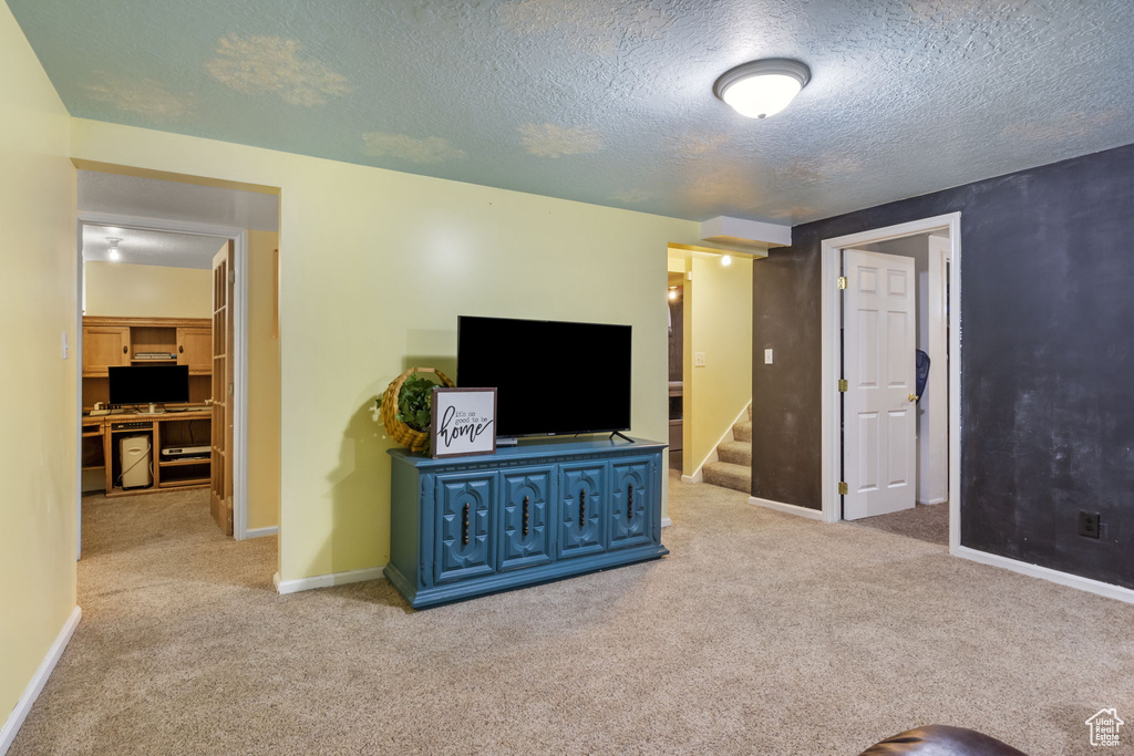 Carpeted living room featuring a textured ceiling