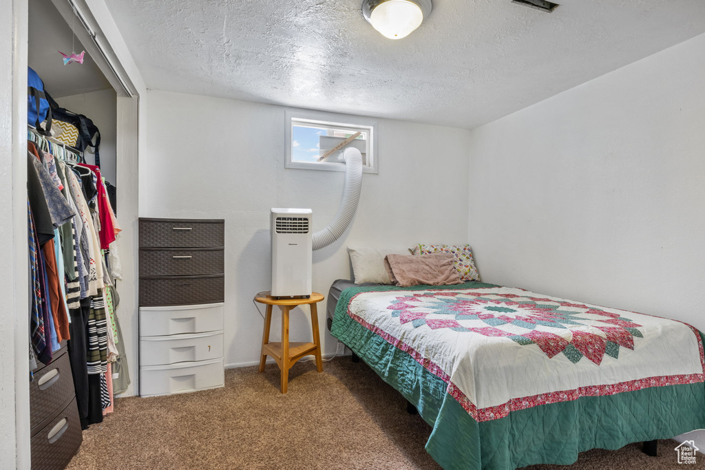 Bedroom with carpet flooring and a textured ceiling