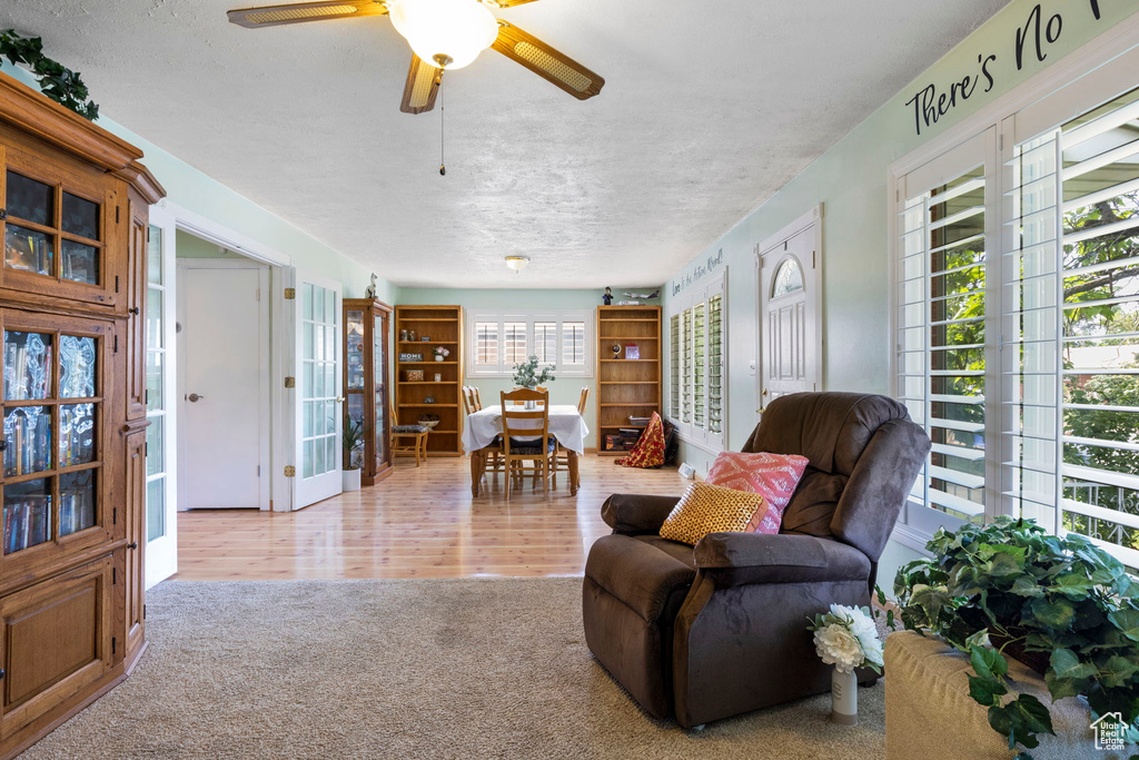 Living room with light wood-type flooring and ceiling fan