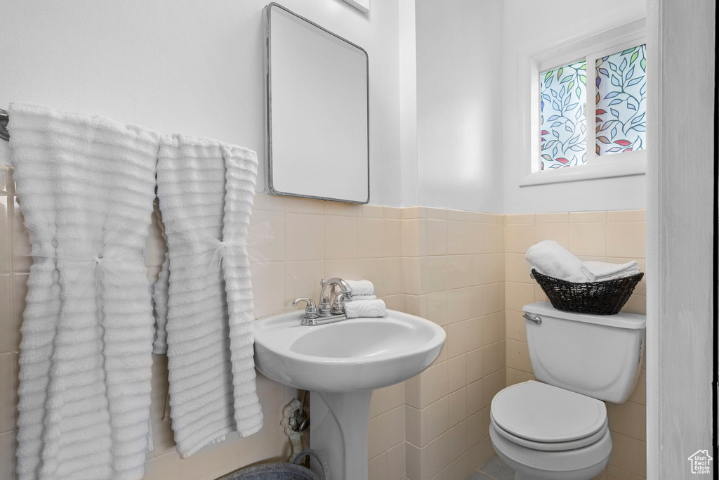 Bathroom featuring tile walls, backsplash, and toilet