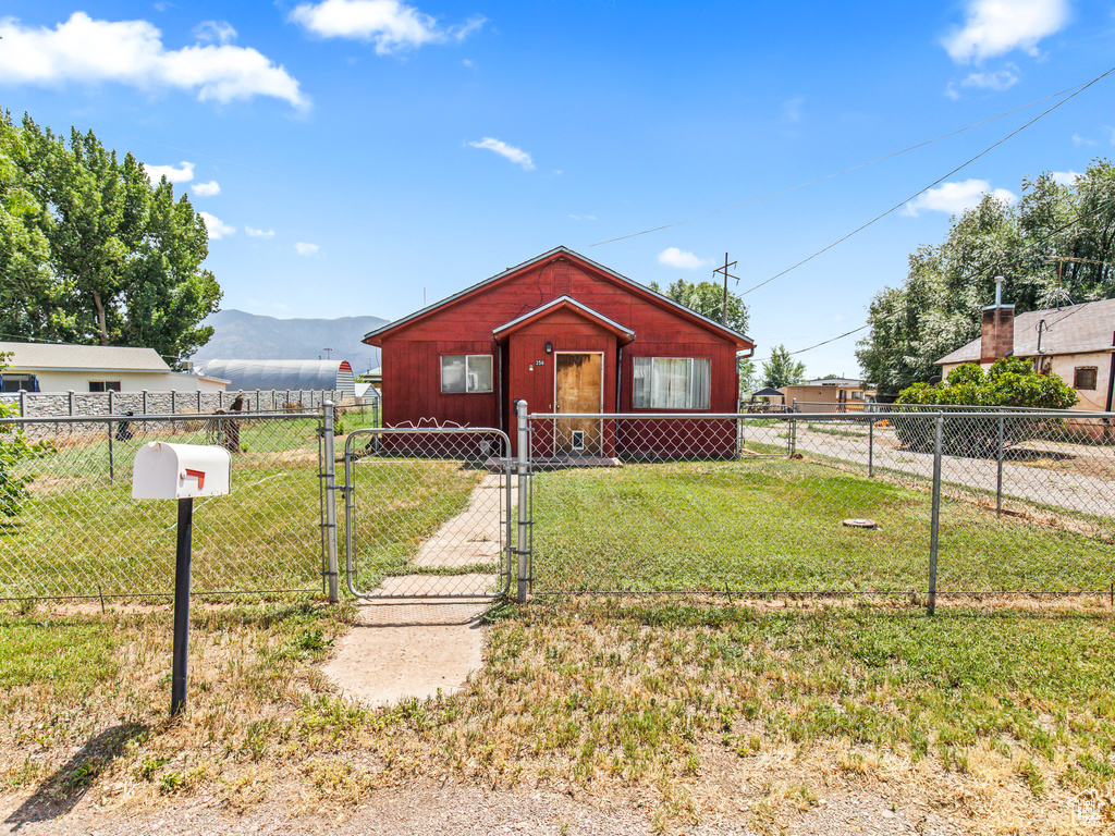 View of front of house featuring a mountain view and a front lawn