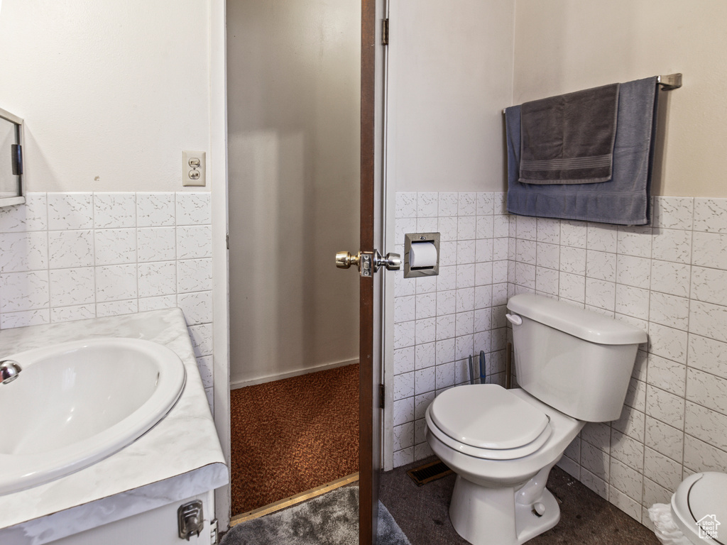 Bathroom with tile walls, toilet, and vanity