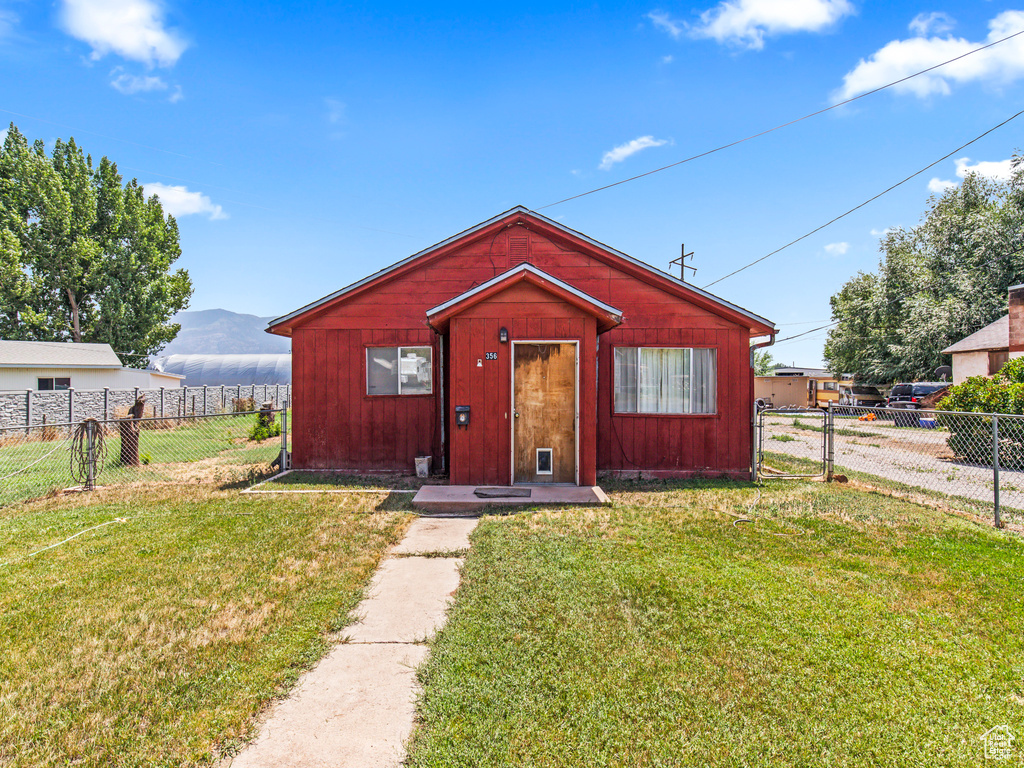 View of front of property featuring a mountain view and a front yard