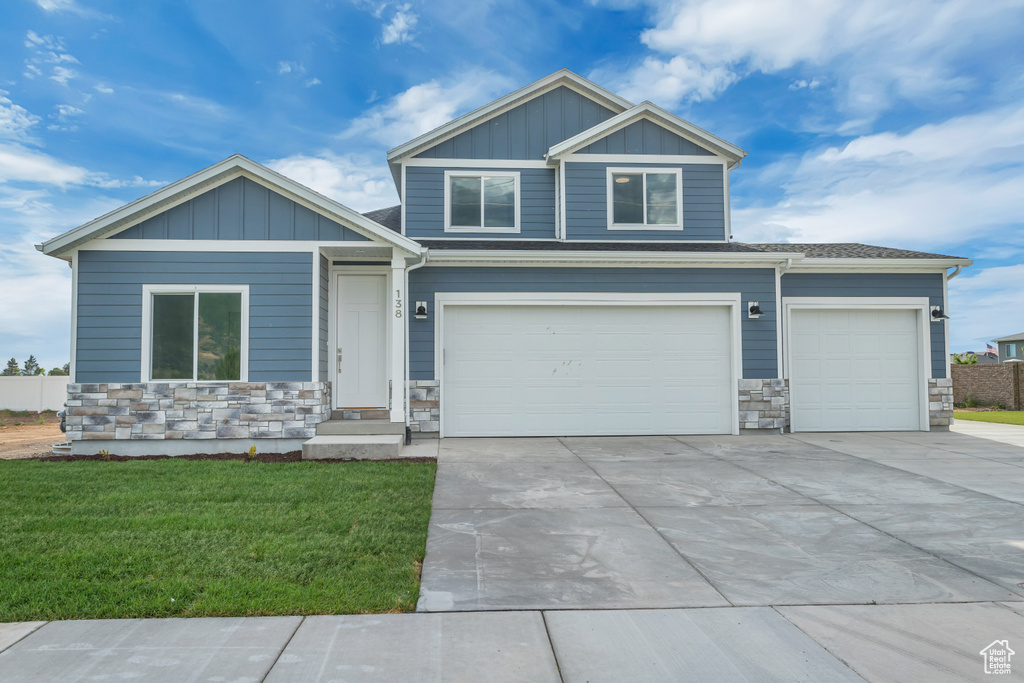 Craftsman house featuring a garage and a front yard