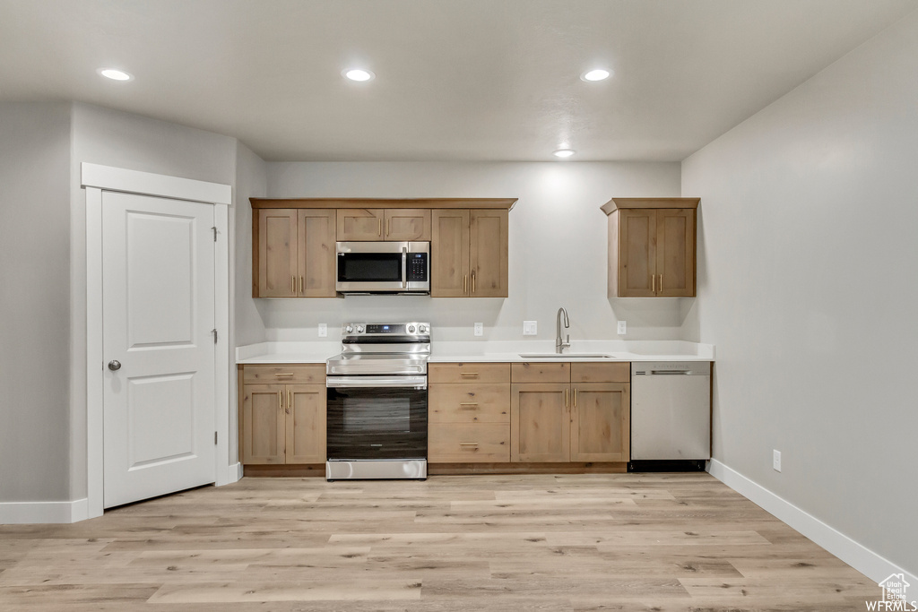 Kitchen featuring sink, appliances with stainless steel finishes, and light hardwood / wood-style floors