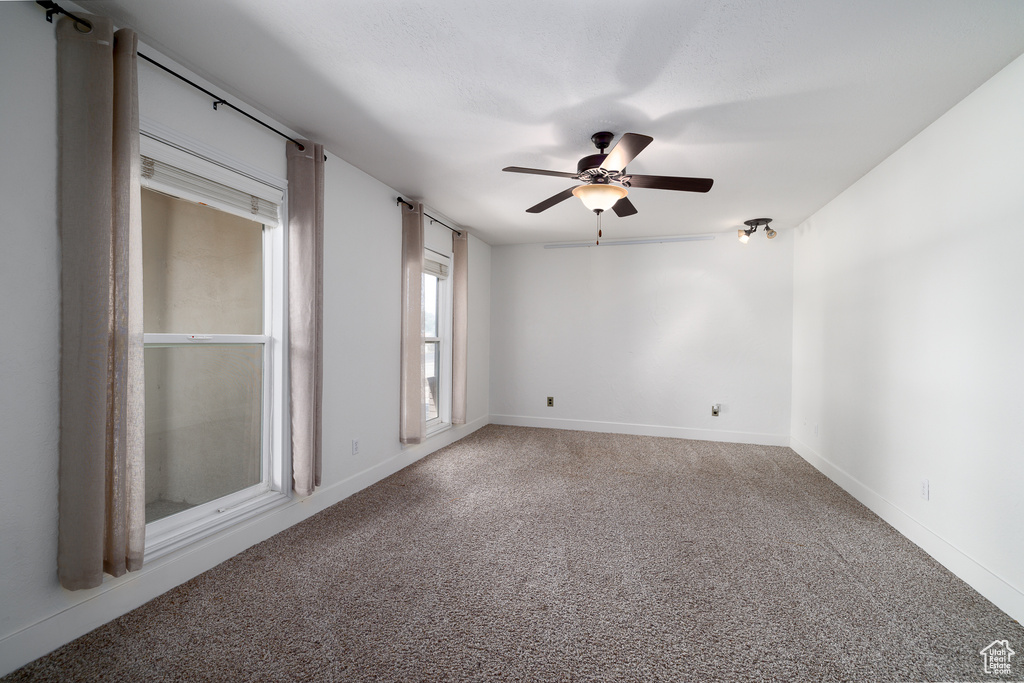 Empty room with carpet floors and ceiling fan