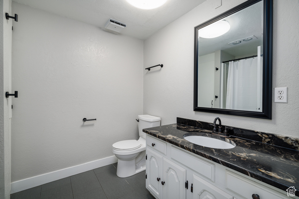 Bathroom featuring vanity, toilet, and tile patterned floors