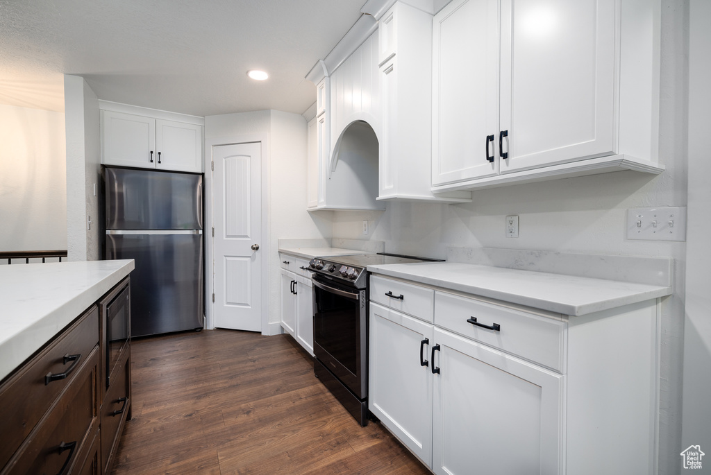 Kitchen featuring appliances with stainless steel finishes, dark hardwood / wood-style floors, and white cabinetry