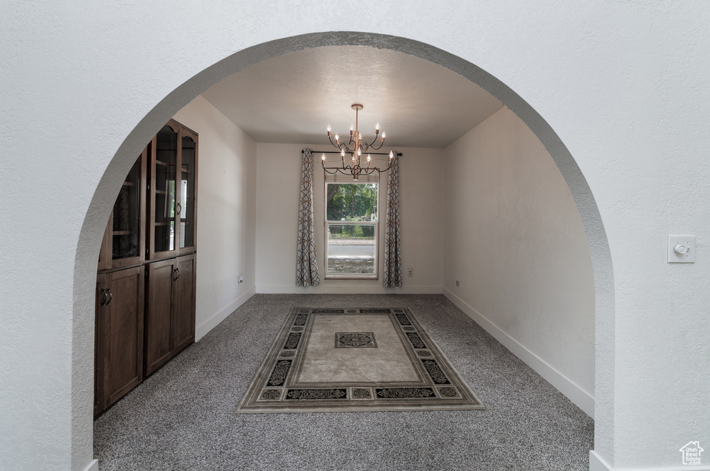 Interior space featuring a notable chandelier and carpet floors