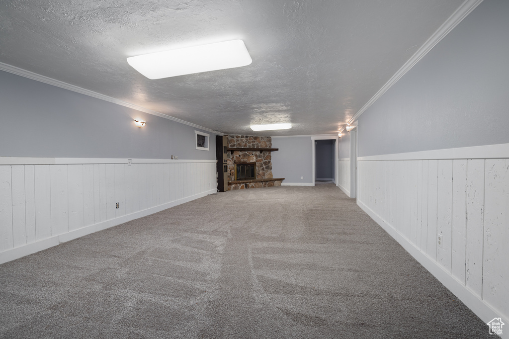 Basement featuring a textured ceiling, carpet, and a fireplace