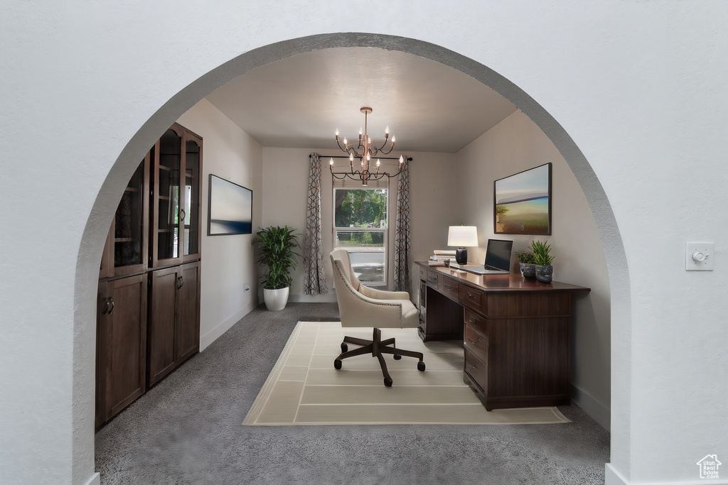 Carpeted home office featuring an inviting chandelier