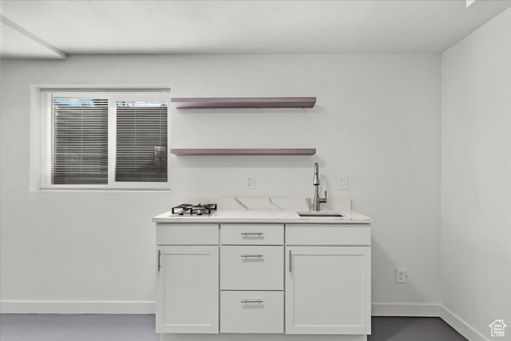 Bar with white cabinetry and sink