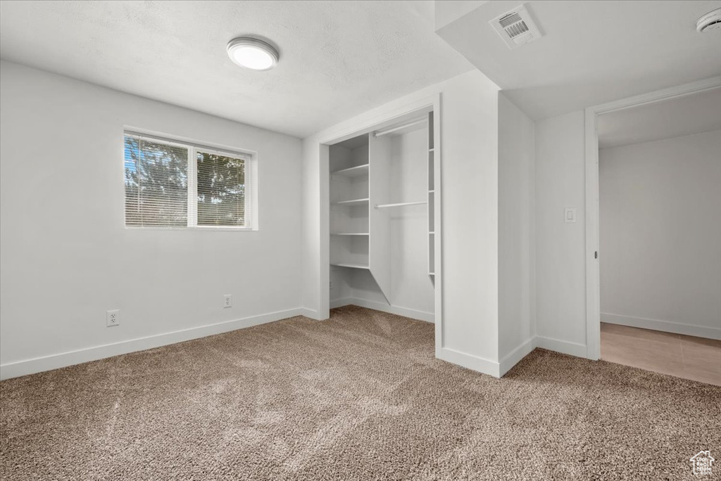 Unfurnished bedroom with a closet and light colored carpet