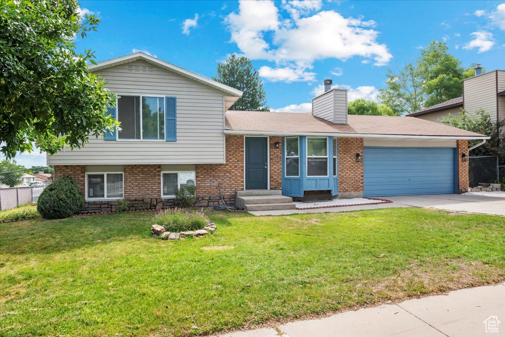 Tri-level home with a garage and a front yard