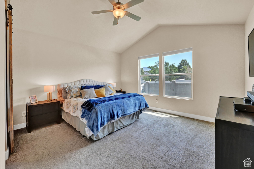 Carpeted bedroom with lofted ceiling and ceiling fan