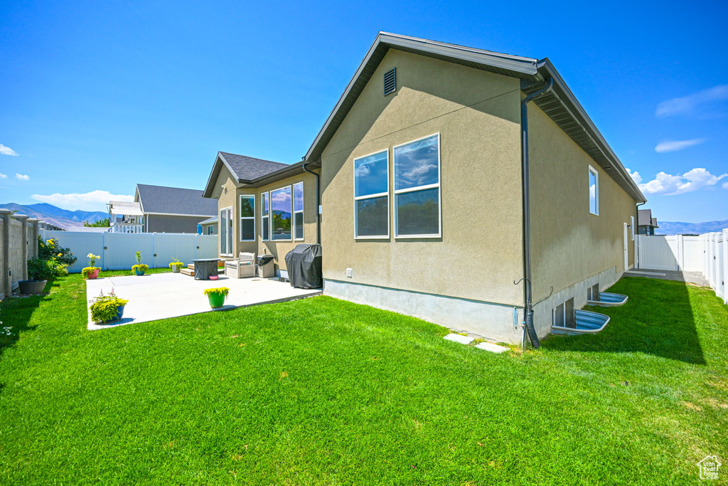 Back of house featuring a patio and a lawn