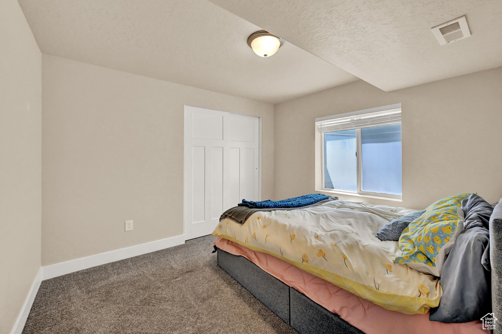 Bedroom with carpet floors and a textured ceiling