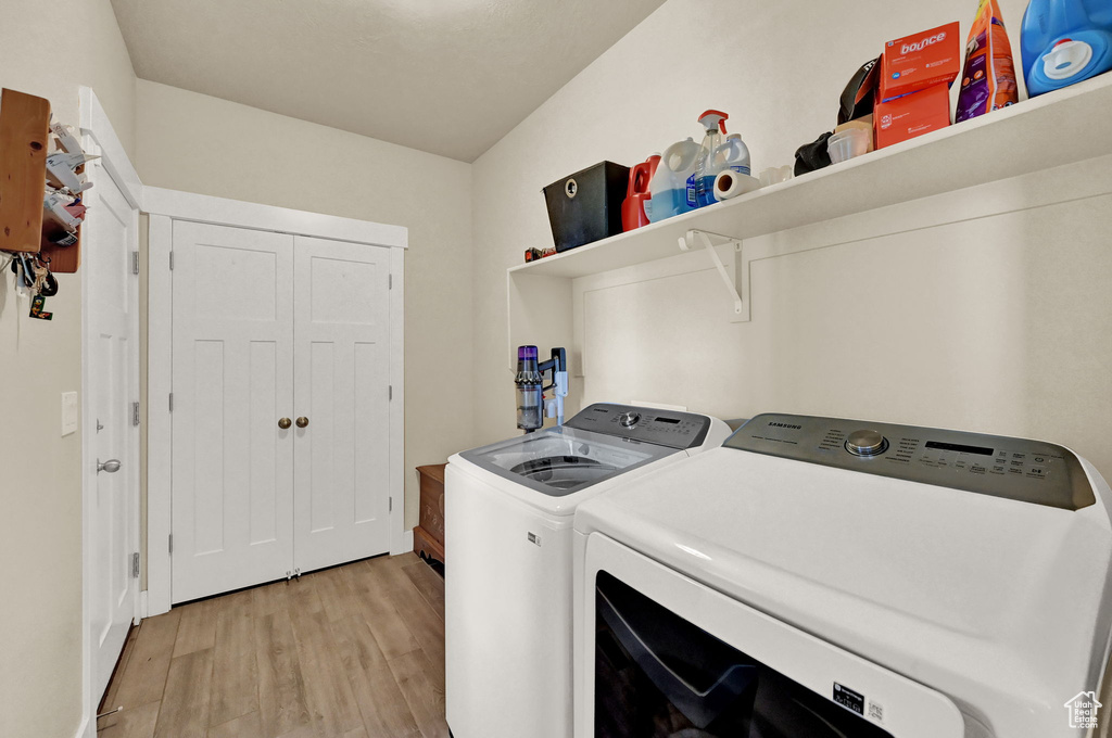 Laundry area with light hardwood / wood-style flooring and independent washer and dryer