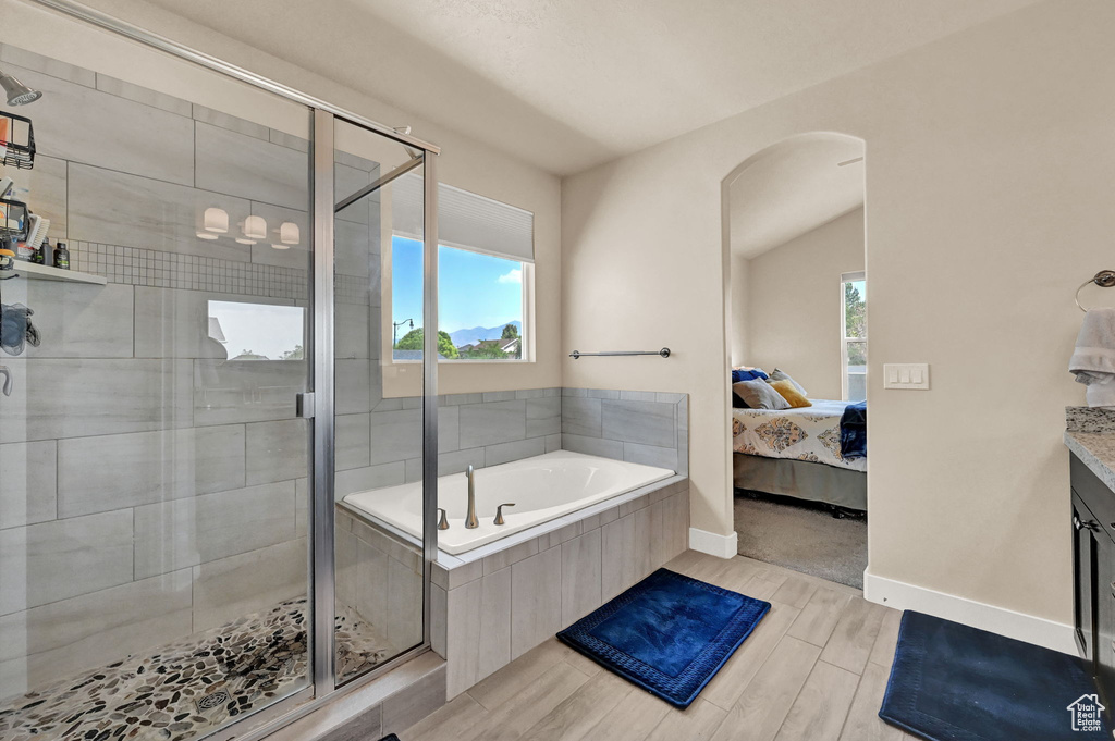 Bathroom featuring vanity, plus walk in shower, and a wealth of natural light