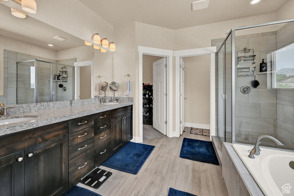 Bathroom with separate shower and tub, hardwood / wood-style flooring, and dual bowl vanity