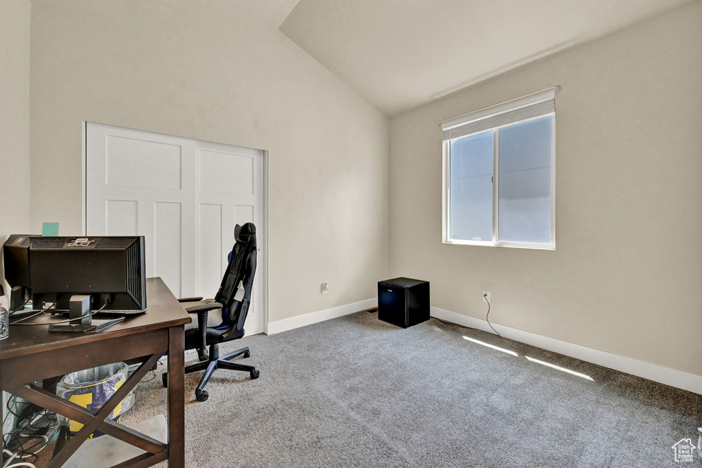 Carpeted office featuring lofted ceiling