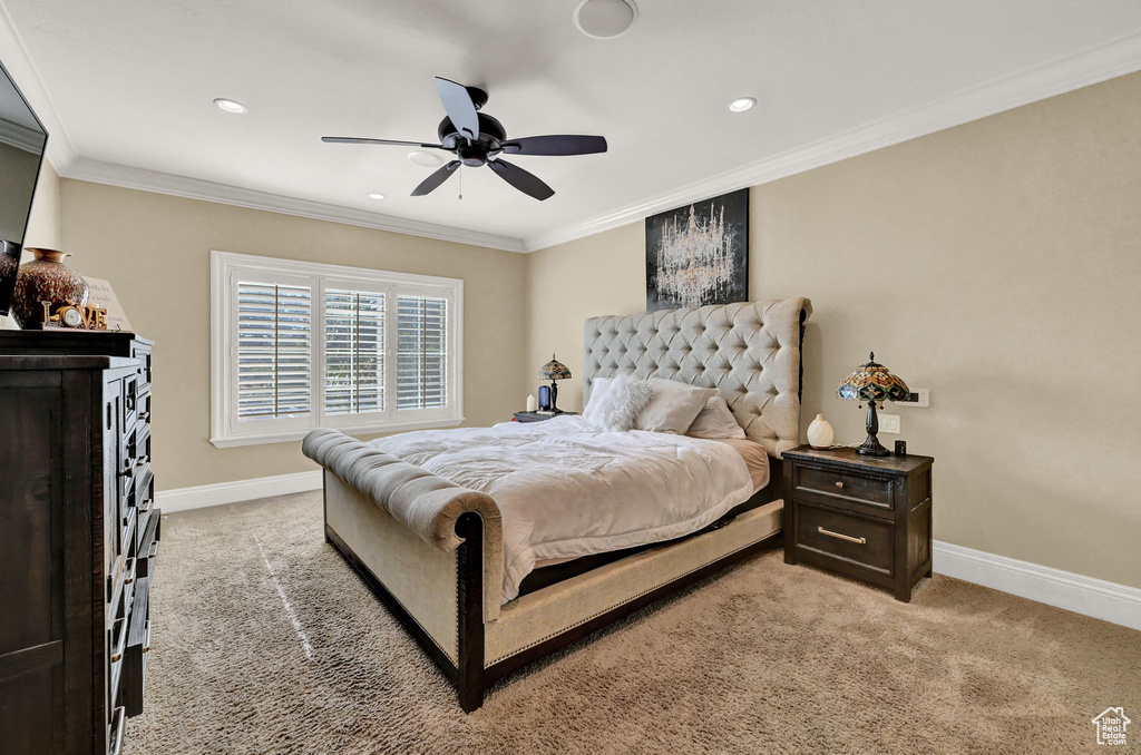 Bedroom with ornamental molding, light colored carpet, and ceiling fan