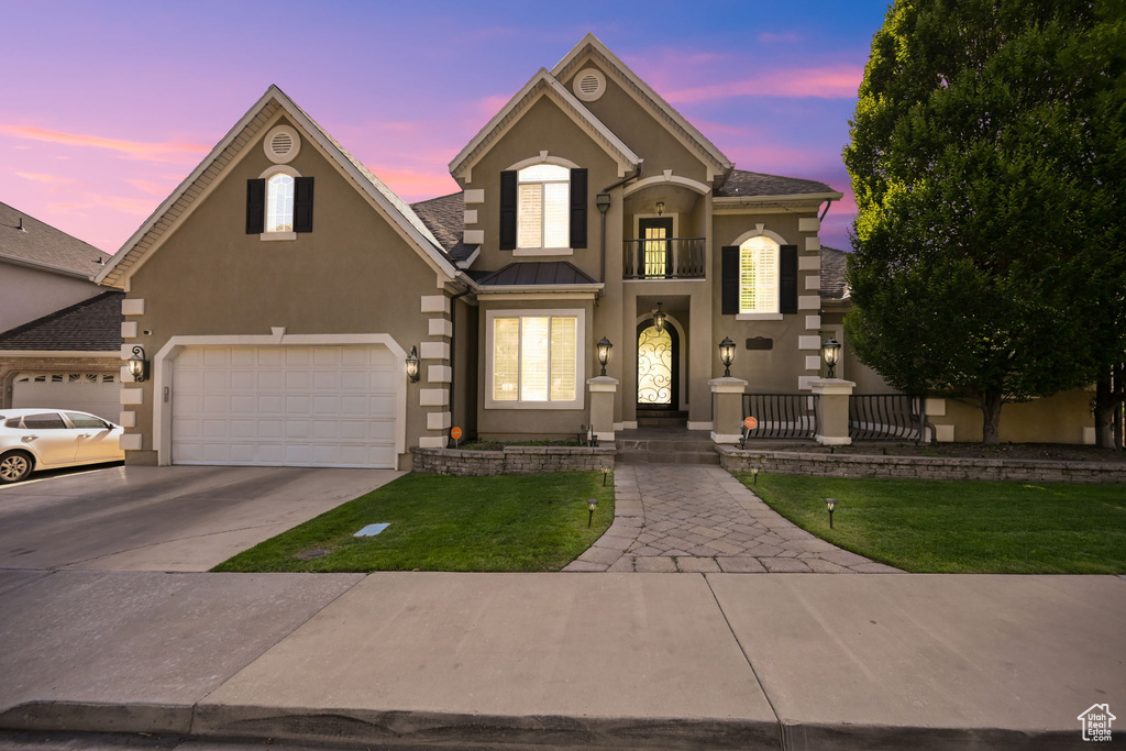 View of front of property with a garage and a balcony