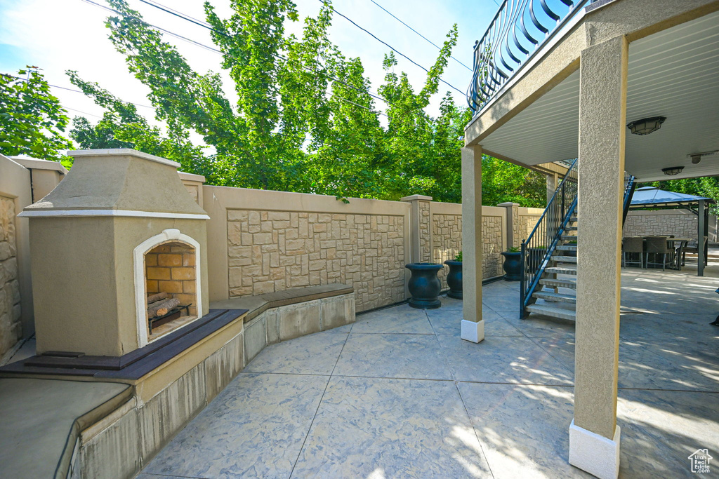 View of patio with exterior fireplace