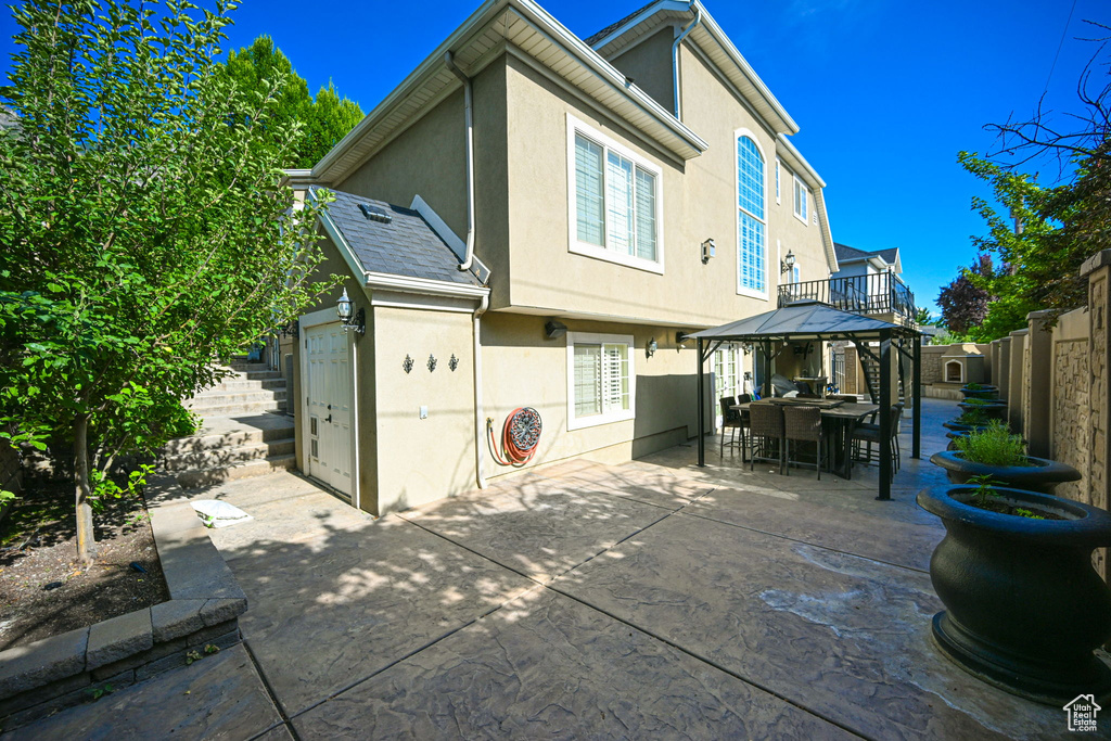 Back of property featuring a gazebo and a patio area