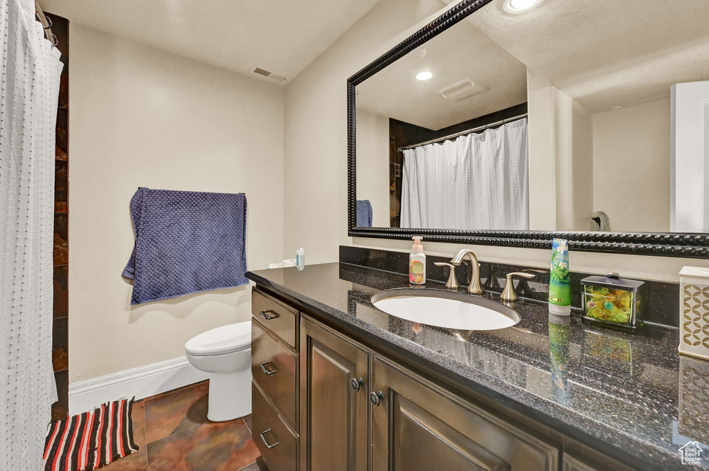 Bathroom with tile patterned flooring, toilet, and vanity