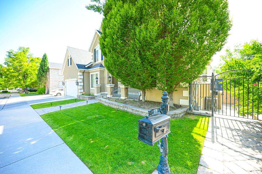 View of front facade featuring a garage and a front yard