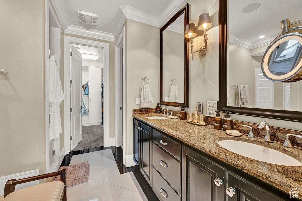 Bathroom featuring tile patterned flooring, double sink vanity, and ornamental molding