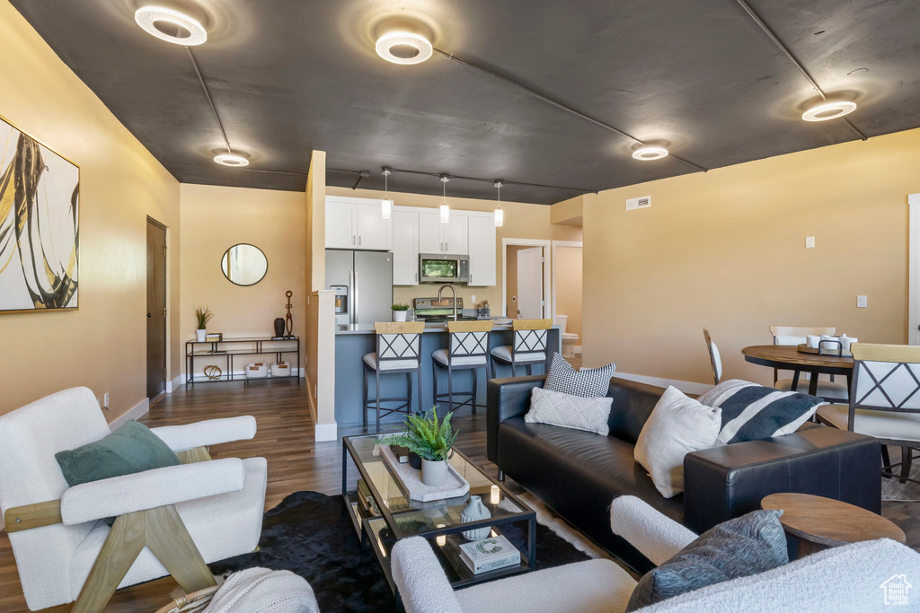 Living room featuring dark hardwood / wood-style floors and track lighting