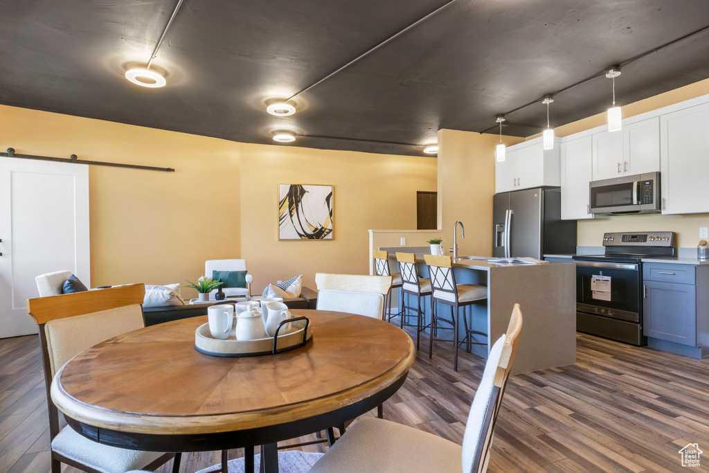 Dining room with dark hardwood / wood-style floors and a barn door