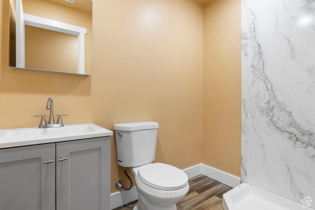 Bathroom featuring vanity, hardwood / wood-style flooring, and toilet