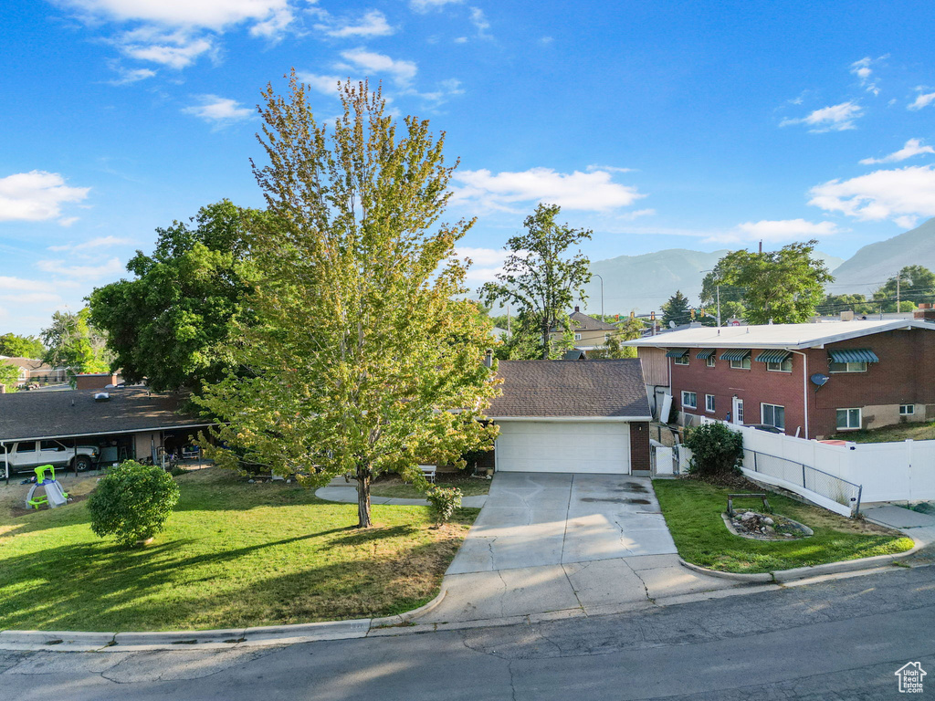 View of front of house with a front lawn and a mountain view