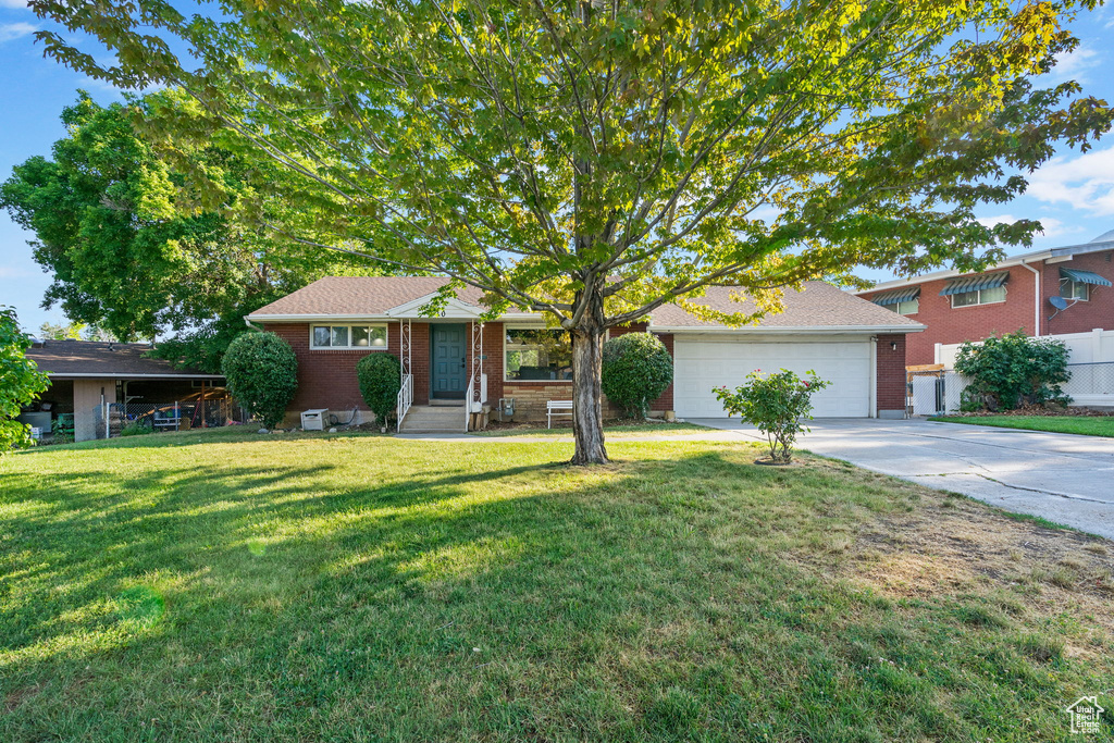 View of front of property featuring a garage and a front yard