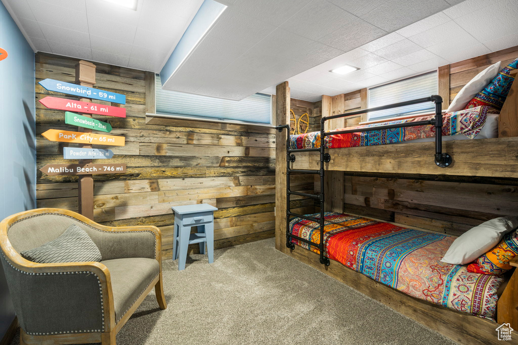 Bedroom featuring wooden walls and carpet flooring