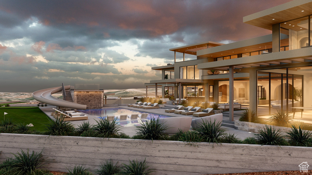 Pool at dusk with a pergola and a water slide