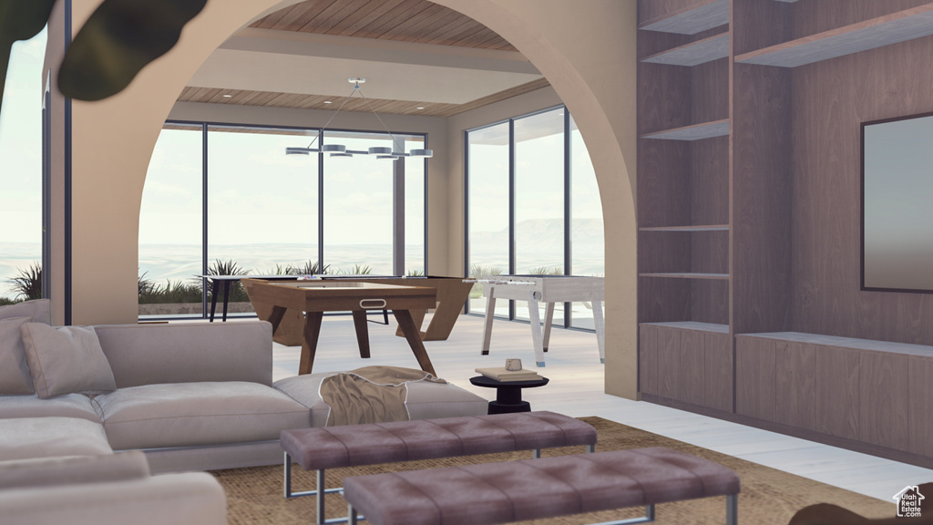 Interior space with built in shelves, light hardwood / wood-style flooring, and an inviting chandelier