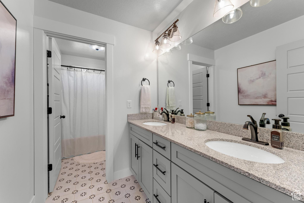 Bathroom featuring tile patterned flooring and dual bowl vanity