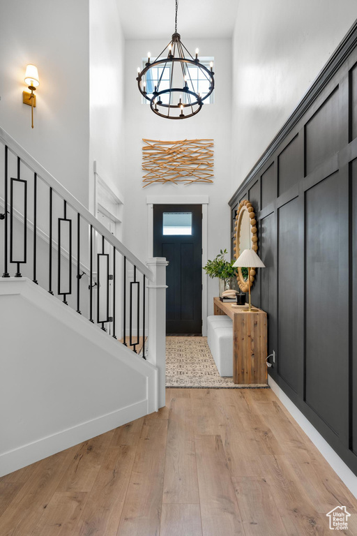 Entrance foyer featuring plenty of natural light, a high ceiling, light wood-type flooring, and an inviting chandelier