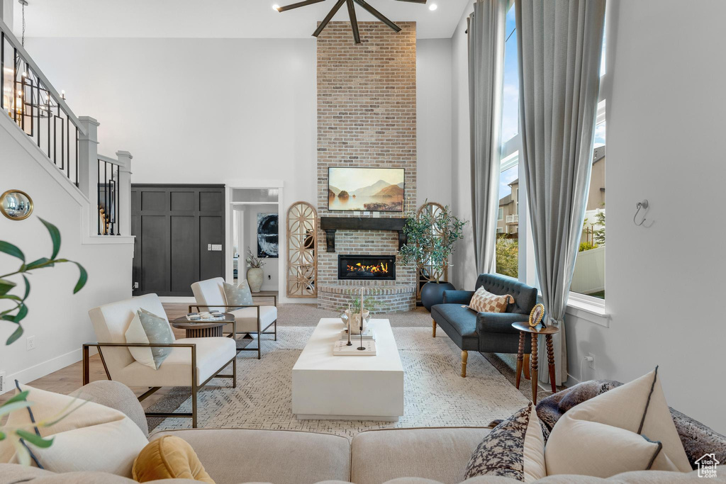 Living room with brick wall, a healthy amount of sunlight, a brick fireplace, and a towering ceiling