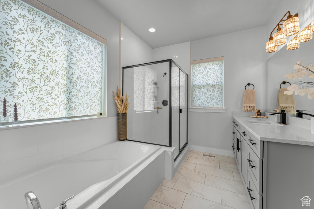 Bathroom with tile patterned floors, vanity, independent shower and bath, and a wealth of natural light