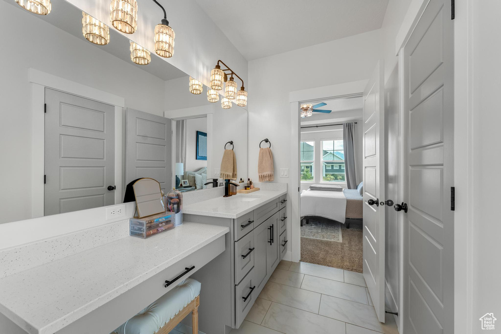 Bathroom featuring ceiling fan with notable chandelier, tile patterned floors, and vanity