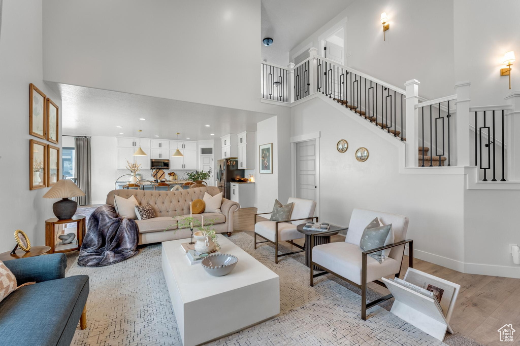 Living room featuring light hardwood / wood-style flooring and a towering ceiling