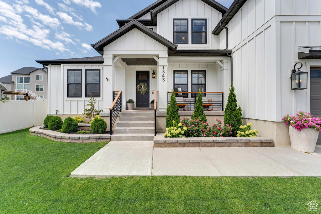 View of front facade featuring covered porch and a front lawn