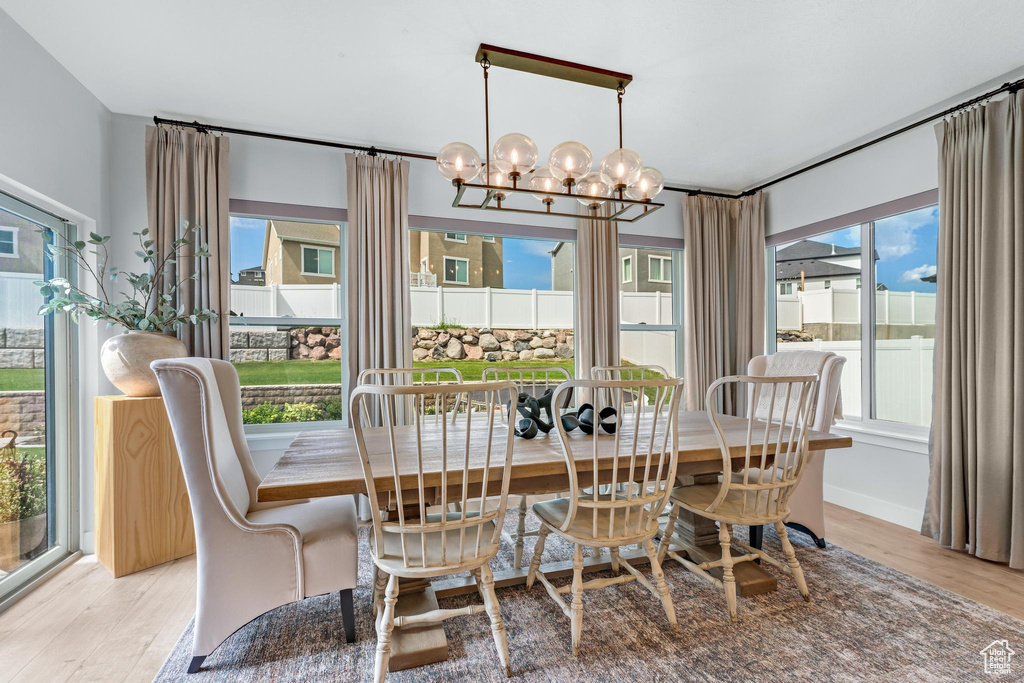 Dining area with light hardwood / wood-style flooring, a chandelier, and plenty of natural light