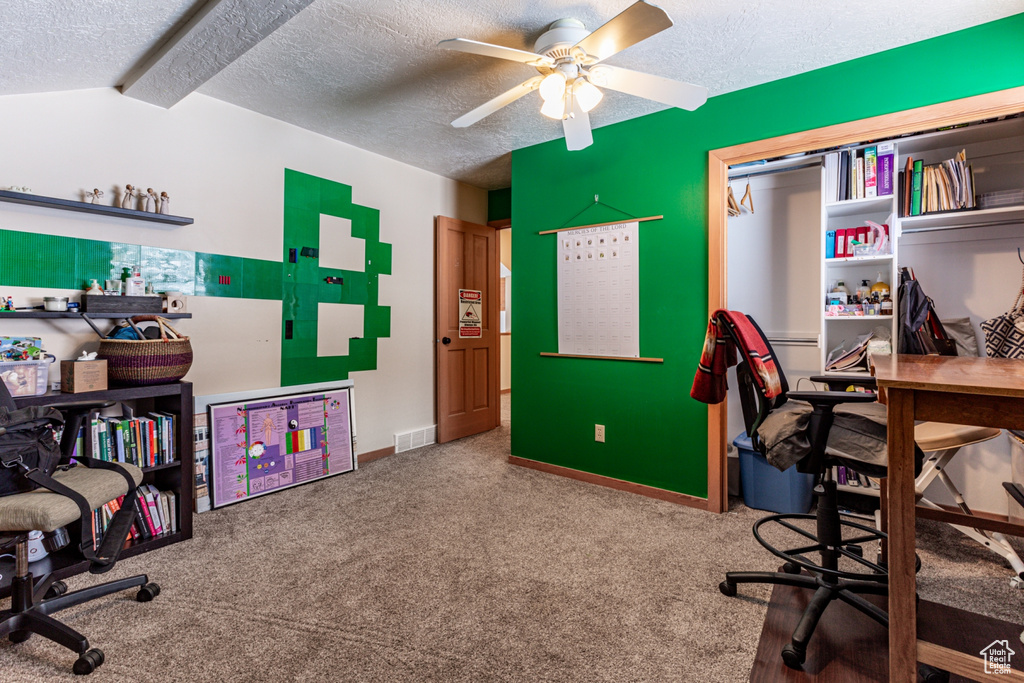 Home office with carpet floors, a textured ceiling, ceiling fan, and lofted ceiling